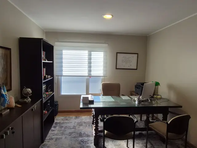 Despacho de la abogada, con escritorio, biblioteca y luz de ventana