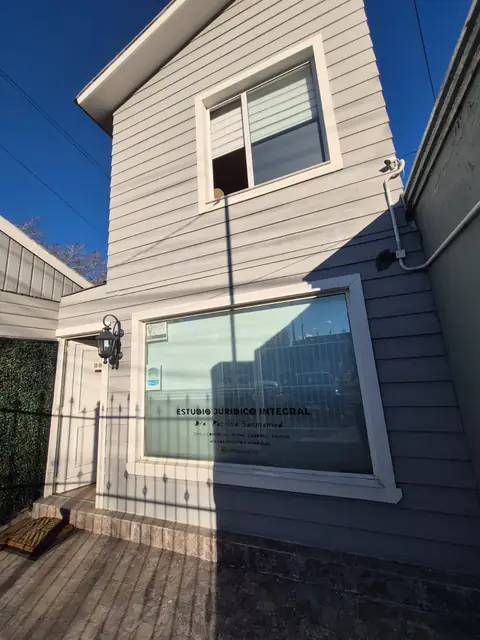 Frente del estudio, una casa de madera gris con el cartel de estudio jurídico en la ventana
